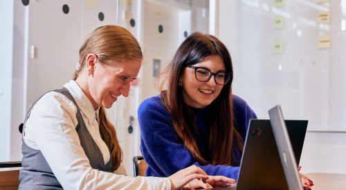 two people working together on laptop