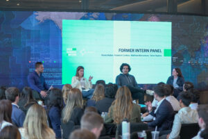 People speaking on panel in front of audience