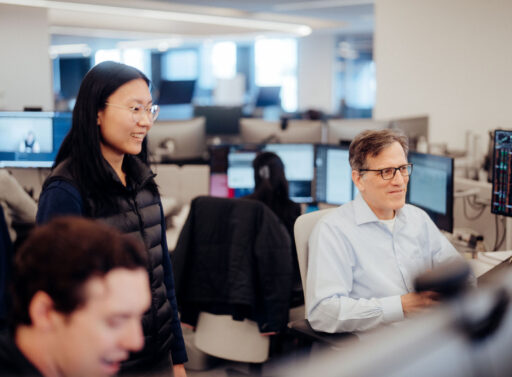 Photo of three people at desks in an office